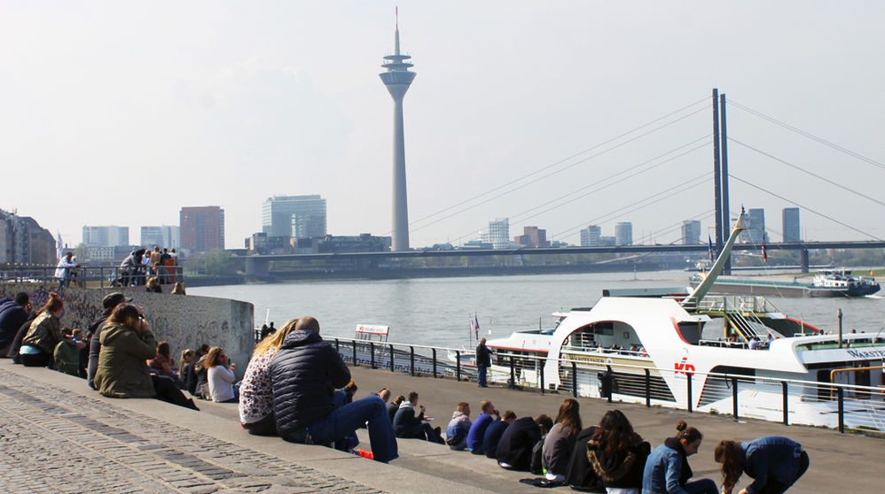 Gemütlich auf den Treppen sitzen und auf den Rheinturm gucken.