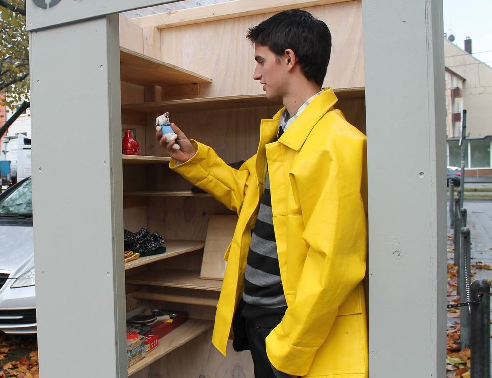 Tauschen, schenken, finden - Jugendliche bauen Givebox in Heerdt Die Jugendlichen schauen sich an, was alles in der von ihnen gebauten Givebox zu finden ist. Stefan von der Jugendberufshilfe findet ein kleines Kuscheltier. (Foto: Jonathan)