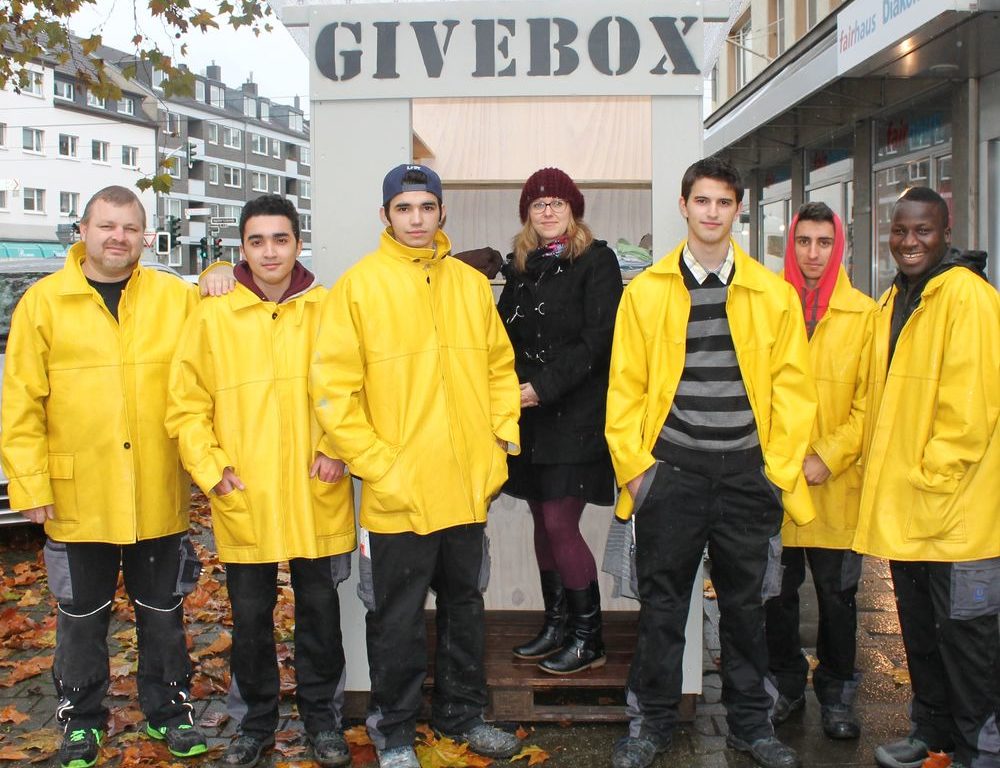 Die Gruppe der Jugendberufshilfe ist stolz auf ihre geleistete Arbeit. Auf dem Bild zu sehen sind die Jugendlichen: Miguel Dacosta Monteiro, Pascal Weihnart, Stefan Luesoreanu, Yasin Bounaanaa und Mamadou Toumhara. Zudem ihr Anleiter Jörg Knüppelberg und in der Givebox steht Carolin Pereira, sie hat das Projekt mitbegründet. (Foto: Jonathan) Die Gruppe der Jugendberufshilfe ist stolz auf ihre geleistete Arbeit. Auf dem Bild zu sehen sind die Jugendlichen: Miguel Dacosta Monteiro, Pascal Weihnart, Stefan Luesoreanu, Yasin Bounaanaa und Mamadou Toumhara. Zudem ihr Anleiter Jörg Knüppelberg und in der Givebox steht Carolin Pereira, sie hat das Projekt mitbegründet. (Foto: Jonathan)