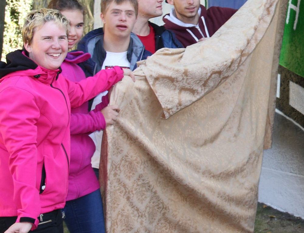 Schüler der Mosaikschule enthüllen die bunte Wand. Copyright: Caritasverband Düsseldorf
