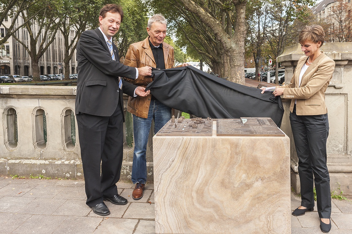 Burkhard Hintzsche (Stadt Düsseldorf), Gerd Kozyk (Allg. Blindenverein Düsseldorf e. V.) und Eva-Maria Illigen-Günther (Tourismus-GmbH) enthüllen den Stadtplan an der Kö. Düsseldorf Marketing & Tourismus GmbH Burkhard Hintzsche (Stadt Düsseldorf), Gerd Kozyk (Allg. Blindenverein Düsseldorf e. V.) und Eva-Maria Illigen-Günther (Tourismus-GmbH) enthüllen den Stadtplan an der Kö. Düsseldorf Marketing & Tourismus GmbH