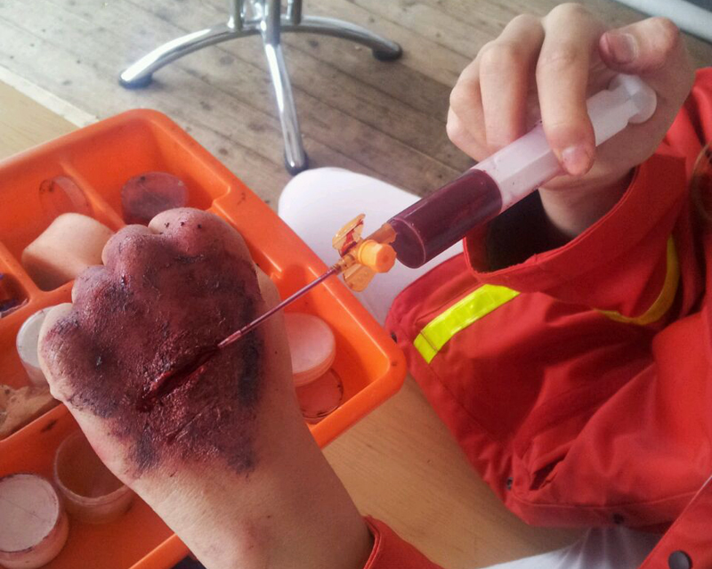 Das Wundenschminken mit täuschend echtem Kunstblut haben die Jugendlichen lange gelernt. Damit stellen sie Notfälle dar und erklären, was zu tun ist. Jugendrotkreuz Düsseldorf