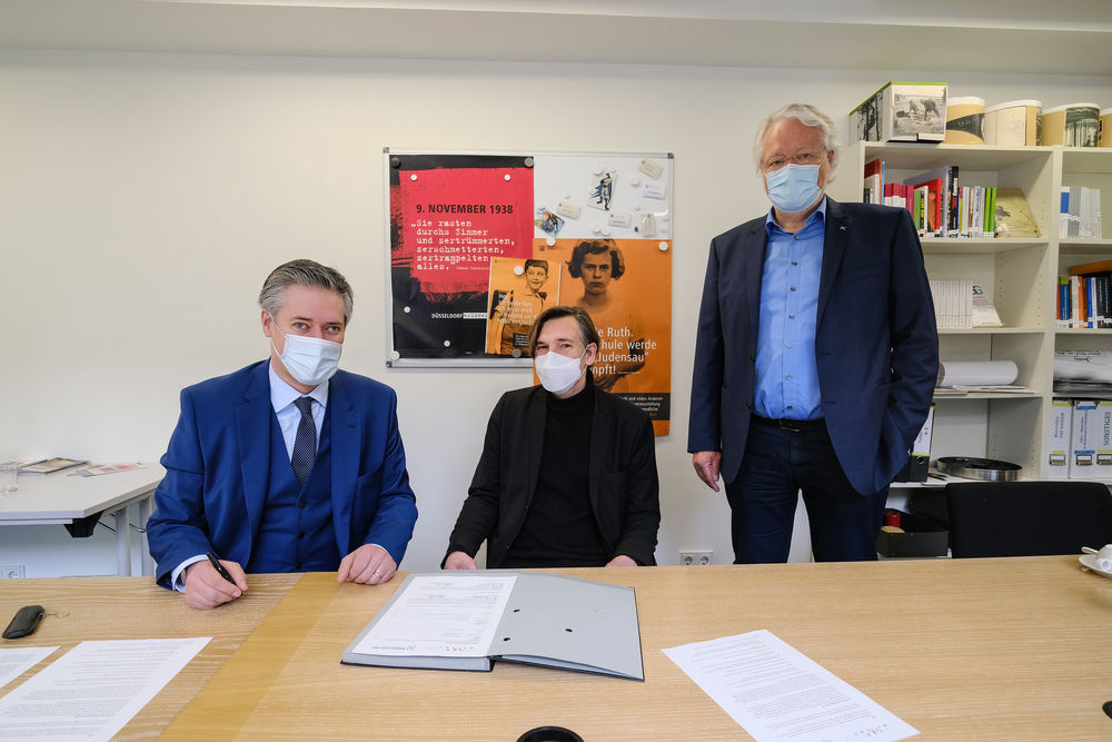 Mahn- und Gedenkstätte vereinbart Bildungspartnerschaft mit der Dieter-Forte-Gesamtschule Um die Partnerschaft zu besiegeln, wurde am Dienstag, den 29. März, ein Kooperationsvertrag von Gedenkstättenleiter Dr. Bastian Fleermann (links), Lehrer Wolfgang A. Noethen (Mitte) sowie Schulleiter Jürgen Weitz (rechts) unterzeichnet. (Foto: Landeshauptstadt Düsseldorf/Michael Gstettenbauer)