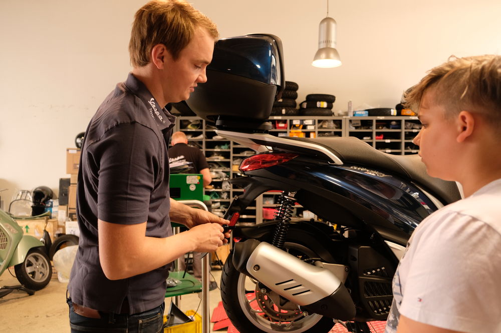 Social Day: Für einen guten Zweck in die Arbeitswelt hineinschnuppern Max Seilheimer erklärt Cassian geduldig die Grundlagen der Zweiradtechnik. (Foto: Christina Behrens)