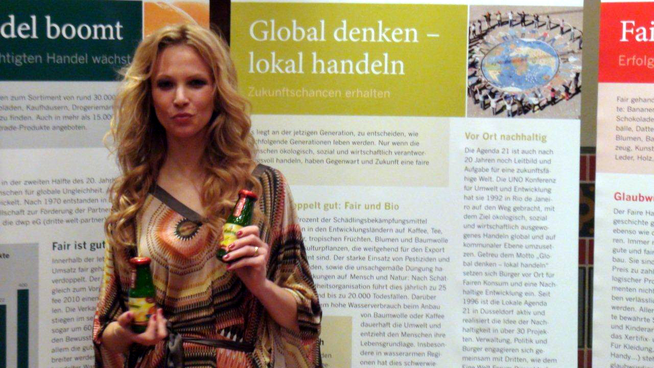 Birte Glang, Moderatorin der Fair Fashion`s Night, posiert vor Fairtrade-Plakaten.  Benedikt Sondermann Birte Glang, Moderatorin der Fair Fashion`s Night, posiert vor Fairtrade-Plakaten. Benedikt Sondermann
