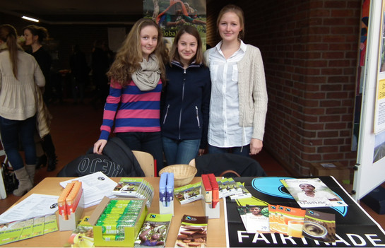 Drei Mitglieder der Fairtrade AG verkaufen Fairtrade-Produkte am Tag der offenen Tür im Foyer des Suitbertus- Gymnasiums. Benedikt Sondermann Drei Mitglieder der Fairtrade AG verkaufen Fairtrade-Produkte am Tag der offenen Tür im Foyer des Suitbertus- Gymnasiums. Benedikt Sondermann