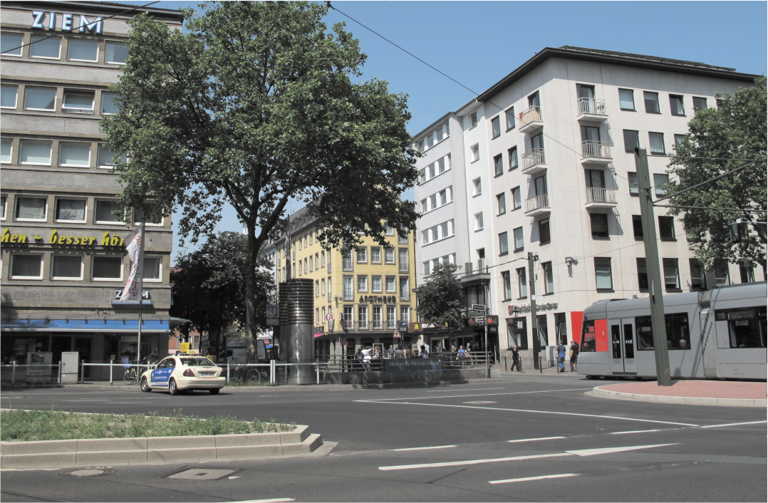 Heinrich-Heine-Allee 2013: Einige Geschäfte – wie die Apotheke oder der Optiker links – wurden nach dem Krieg wieder hergerichtet und existieren bis heute. Die Kaiser-Wilhelm-I.-Statue befindet sich heute am Martin-Luther-Platz. Aurel Gröne Heinrich-Heine-Allee 2013: Einige Geschäfte – wie die Apotheke oder der Optiker links – wurden nach dem Krieg wieder hergerichtet und existieren bis heute. Die Kaiser-Wilhelm-I.-Statue befindet sich heute am Martin-Luther-Platz. Aurel Gröne