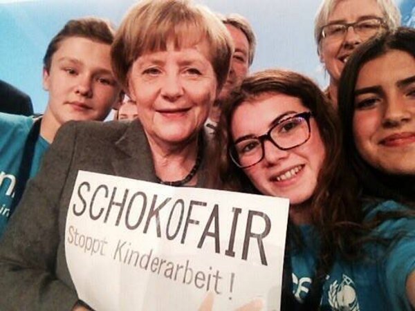 Ein Selfie mit der Kanzlerin. Die Schüler werben in ganz Deutschland für faiere Schokolade. Dabei treffen sie viele Promis und machen Fotos mit ihnen und dem Logo der Schokofair-AG. Hier trafen sie Angela Merkel. Schokofair-AG Ein Selfie mit der Kanzlerin. Die Schüler werben in ganz Deutschland für faiere Schokolade. Dabei treffen sie viele Promis und machen Fotos mit ihnen und dem Logo der Schokofair-AG. Hier trafen sie Angela Merkel. Schokofair-AG