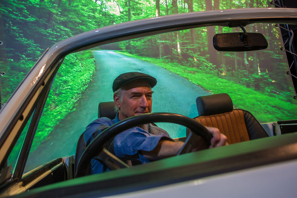Museumsdirektor Bernd Desinger im Triumph-Cabrio vor der Rückprojektion Foto: Filmmuseum Düsseldorf