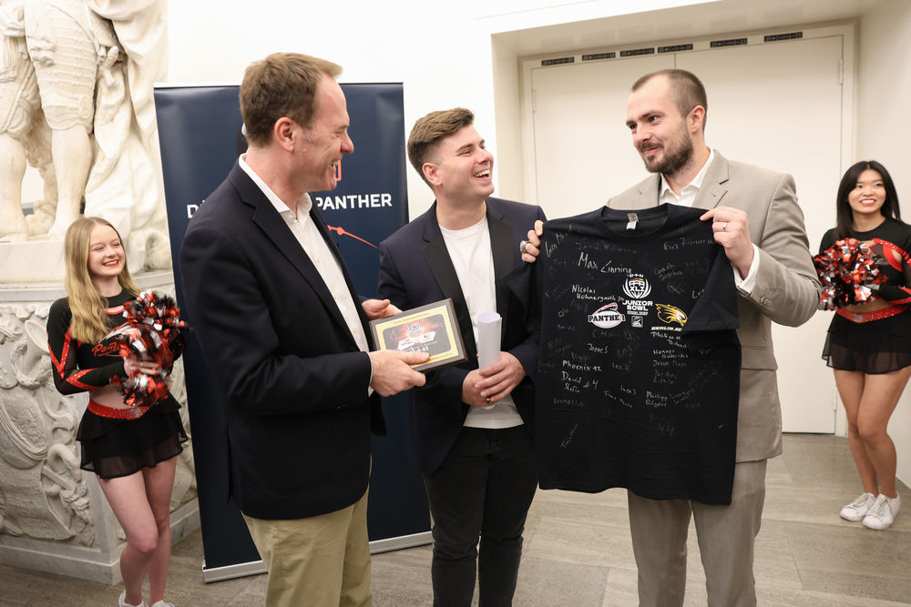 Die Panther-Cheftrainer Peter Daletzki (M.) und Marvin Damm (r.) übergaben Oberbürgermeister Dr. Stephan Keller ein T-Shirt mit den Unterschriften des siegreichen Teams im Junior Bowl 2023 (Foto: Landeshauptstadt Düsseldorf/Melanie Zanin) Die Panther-Cheftrainer Peter Daletzki (M.) und Marvin Damm (r.) übergaben Oberbürgermeister Dr. Stephan Keller ein T-Shirt mit den Unterschriften des siegreichen Teams im Junior Bowl 2023 (Foto: Landeshauptstadt Düsseldorf/Melanie Zanin)