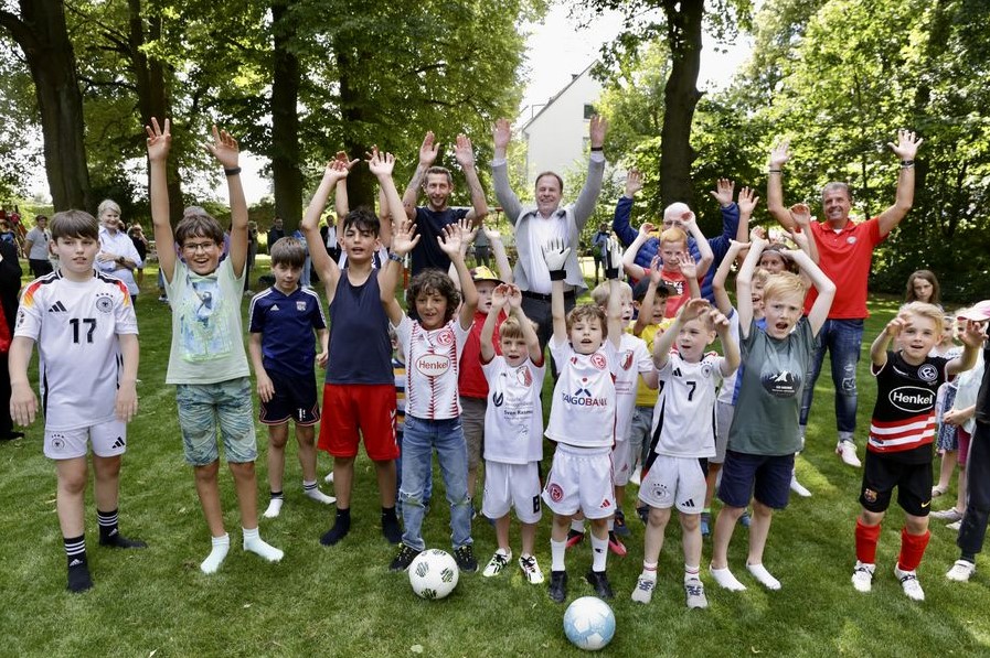 Die Kicker freuen sich mit Ex-Profi Stefan Kießling und Oberbürgermeister Stephan Keller über den Bolzplatz in Volmerswerth. (Foto: Landeshauptstadt Düsseldorf/Ingo Lammert)