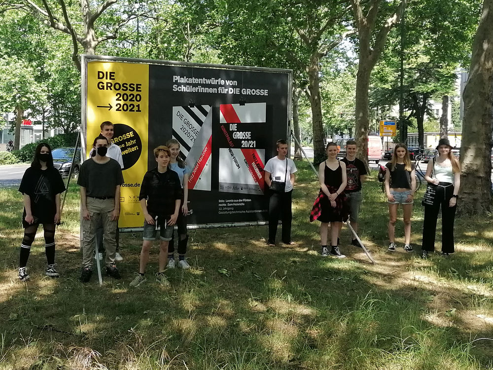 Schüler*innen der Lore-Lorentz-Schule stehen vor einem der selbstentworfenen Plakate. (Foto: RIEDEL)