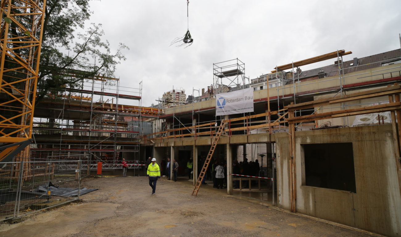 Der Richtkranz wird beim Richtfest des neuen Erweiterungsgebäudes der Maria-Montessori-Gesamtschule in die Höhe gezogen. (Foto: Landeshauptstadt Düsseldorf/Ingo Lammert)