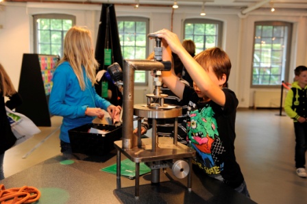 In der "Ist das möglich?"-Ausstellung im LVR-Industriemuseum Oberhausen kann man selbst Hand anlegen. Hier zum Beispiel wird die Widerstandsfähigkeit verschiedener Papiere getestet. © LVR-Industriemuseum, Foto: Jürgen Hoffmann