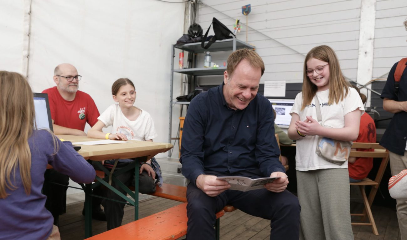 Mina zeigt Keller die aktuelle Ausgabe der Düsseldörfchen-Zeitung. (Foto: Landeshauptstadt Düsseldorf / Ingo Lammert)